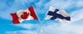 crossed national flags of Canada and Finland flag waving in the wind at cloudy sky. Symbolizing relationship, dialog, travelling