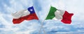 crossed national flags of Chile and Italia flag waving in the wind at cloudy sky. Symbolizing relationship, dialog, travelling