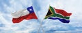 crossed national flags of Chile and South Africa flag waving in the wind at cloudy sky. Symbolizing relationship, dialog, Royalty Free Stock Photo
