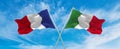 crossed national flags of France and Italia flag waving in the wind at cloudy sky. Symbolizing relationship, dialog, travelling