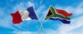 crossed national flags of France and South Africa flag waving in the wind at cloudy sky. Symbolizing relationship, dialog, Royalty Free Stock Photo