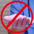 Crossed out hand in a medical protective glove, closeup. Outstretched hand of a doctor in a red circle banned
