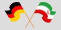 Crossed and waving flags of Iran and Germany