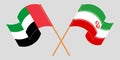 Crossed and waving flags of Iran and United Arab Emirates