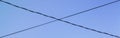 Crossed wires against a blue sky. Royalty Free Stock Photo