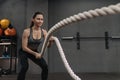 Crossfit female athlete exercising with battle ropes at gym Royalty Free Stock Photo