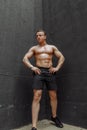 Strong and muscular bodybuilder showing his body near concrete wall Royalty Free Stock Photo