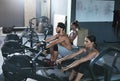 Crossfit. People Exercising On Rowing Machine In Training Gym