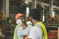 Crossing arms to greet good friendship, unity, smiles between two African American industrial workers.