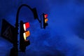 Crossing the city with a traffic light in the evening. Red and orange traffic lights with traffic signs against the blue sky Royalty Free Stock Photo