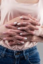 Young tidy woman with white manicure intertwining fingers Royalty Free Stock Photo