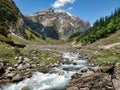 Crossing river by ropes in a scenic valley with mighty Indian Himalayan Mountains and blue sky. Hi