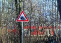 Crossing sign with train traveling, view from a rural road Royalty Free Stock Photo