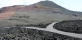 Crossoads in lunar landscape of Lanzarote with red volcanic mountains on the background, Canary Islands. Royalty Free Stock Photo