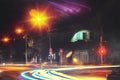 Crossroads of a lonely night provincial town. Red traffic lights in city. Headlight in motion blur