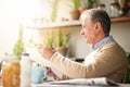 This crossword looks like a challenge. Cropped shot of a senior man reading a newspaper with his breakfast outdoors. Royalty Free Stock Photo