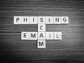 Crossword phising scam email made from square letter tiles against black background.