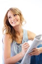 Crosswords are a cure for boredom. A pretty young woman doing a crossword puzzle in the newspaper. Royalty Free Stock Photo