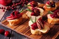 Crostini appetizers with apples, cranberries and brie, close up on a wooden platter Royalty Free Stock Photo