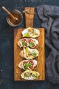 Crostini with fruits, cheese and herbs on rustic wooden board Royalty Free Stock Photo