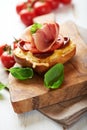 Crostini with prosciutto on wooden board