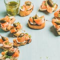 Crostini with smocked salmon, pesto sauce, watercress, capers. Square crop