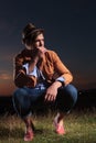 Crouched casual man holds straw in mouth Royalty Free Stock Photo