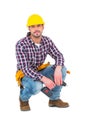 Crouching handyman holding power drill Royalty Free Stock Photo