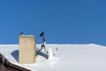 A crow stands on the satellite dish on the roof in winter, and next to it are pigeons, the brotherhood of the crow and the pigeons Royalty Free Stock Photo