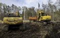 CROW WING CO, MN - 10 MAY 2023: Yellow Excavators and Orange Truck