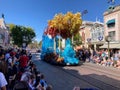 A crowd admiring the famous daily parade with frozen characters and set rolling by on the streets of Disneyland