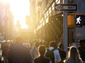 Crowd of anonymous people walking down the sidewalk with bright sunlight in the background on a busy street in Midtown Manhattan, Royalty Free Stock Photo