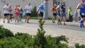 Crowd of athletes running at the marathon in background