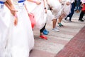 Crowd of brides prepares for their race by lining up in front of starting line, in which groom will serve as their goal. It`s a Royalty Free Stock Photo