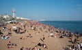 Crowd of British people sunbathing swimming and relaxing in the beach at summer. Leisure time outdoor