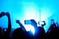 the crowd at a concert festival takes photos and videos on a smartphone