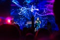 Crowd at concert. People silhouettes on backlit by bright blue and purple stage lights. Cheering crowd in colorful stage lights. R Royalty Free Stock Photo