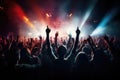 Crowd at concert with raised hands and bright stage lights in background, Crowd cheering at a live music concert and raising their Royalty Free Stock Photo