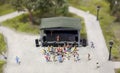 People dancing in a park at a concert in front of the stage in a miniature world setup