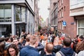 People in orange clothing are sailing in a boat on the canals of Amsterdam on King\'s Day