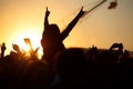 The crowd enjoys the summer music festival, sunset, the silhouettes hands up Royalty Free Stock Photo