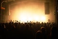 crowd in front of a stage at a music festival in the light of spotlights.