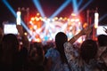 Crowd of hands up concert stage lights and people fan audience silhouette raising hands in the music festival rear view with Royalty Free Stock Photo