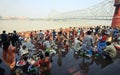 Crowd of Hindu pilgrims assemble at bank of river and pray for late ancestors