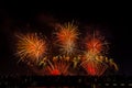 Crowd looks holiday fireworks in dark evening sky