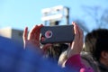 Crowd member takes photo with Apple Iphone at political rally