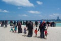 Crowd of muslim people walking towards the ocean