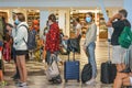 A crowd of passangers in an airport terminal. People stand in line with luggage and face masks ready to depart, cancellations in p