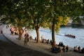 Crowd of people around the river during the golden hour in Paris, France