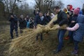 Crowd of people celebrating Masnytsya - pagan holiday of farewell to winter, preparing the straw scarecrow for burning